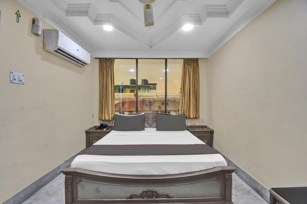 a bed in a room with a large window at Collection O Aafreen Tower Near St. Thomas's Church in Kolkata