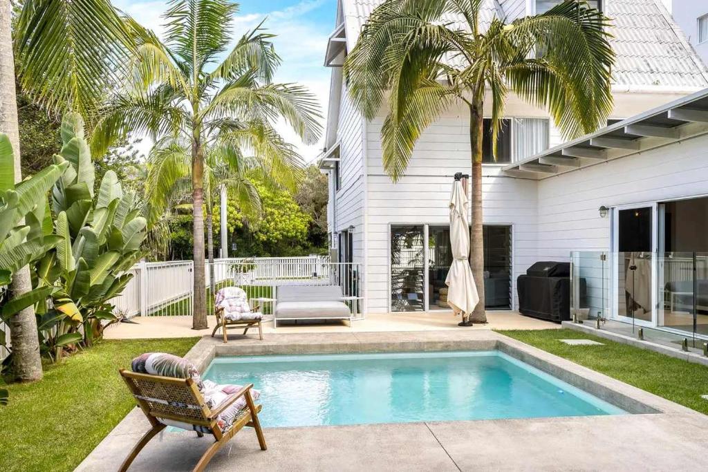 a swimming pool in the backyard of a house at Barra Luxe Beach House 4BR Yaroomba Beach Stay in Yaroomba