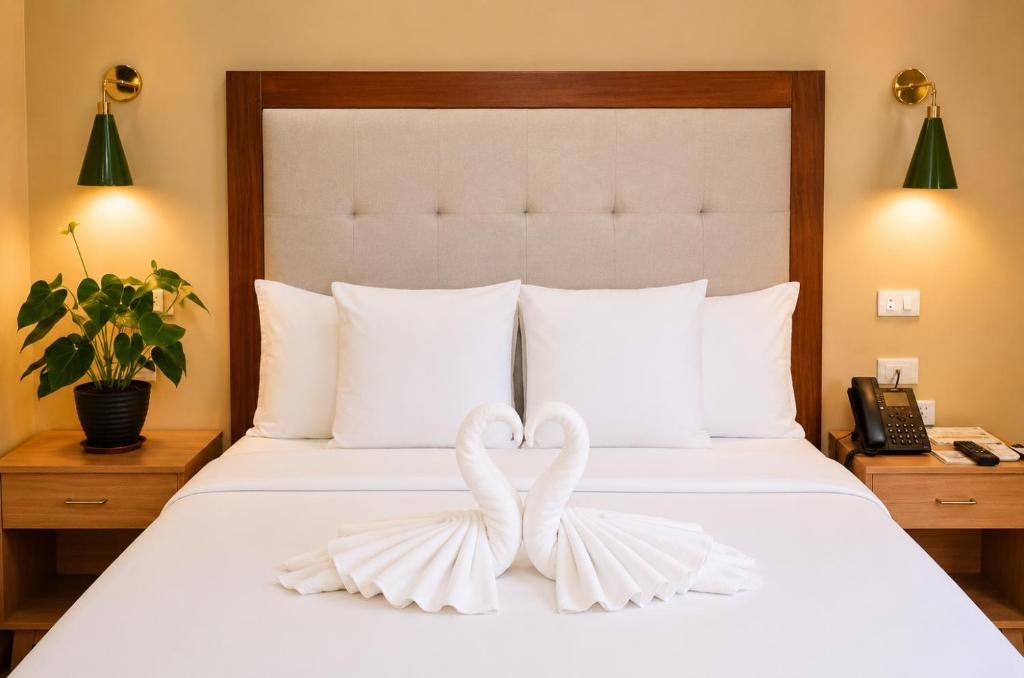 two white swans forming a heart on a bed at Sky Garden Homestay in Olongapo