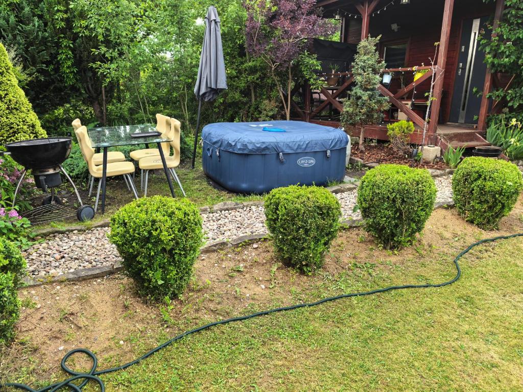a garden with a blue tub and a table and chairs at Domek Nad Morzem in Kołobrzeg