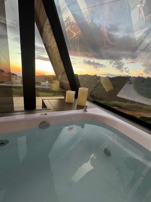 a jacuzzi tub in a room with a view at Chalé Cabana Morro dos Ventos in Chapada dos Guimarães