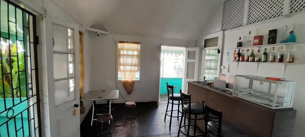 a kitchen with a bar and chairs in a room at Guest house in Basseterre