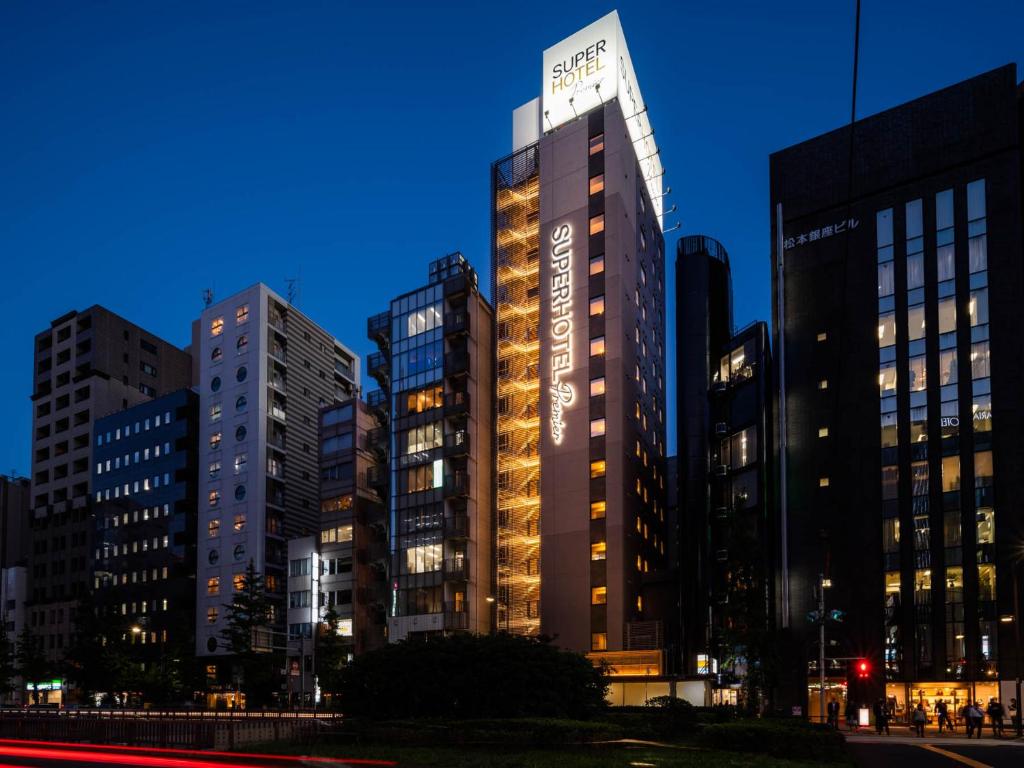 a tall building in a city at night at Super Hotel Premier Ginza in Tokyo