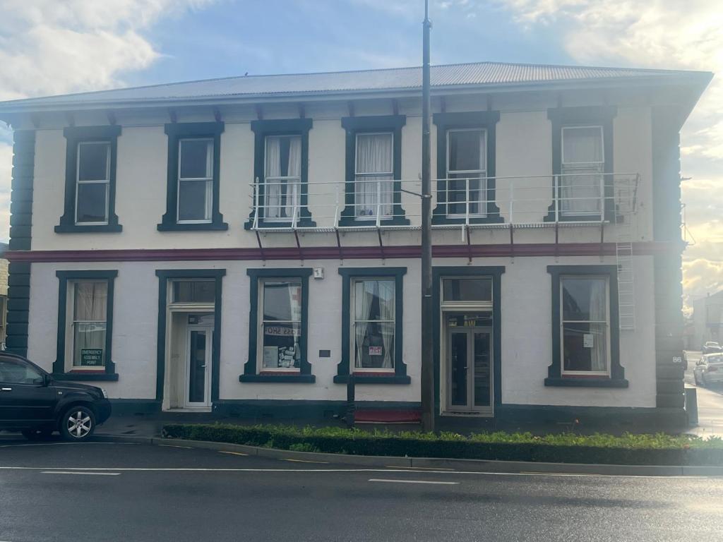 a white house with a car parked in front of it at Sullivans backpackers in Waimate