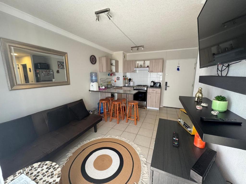 a living room with a couch and a kitchen at Acogedor apartamento in Quilpué