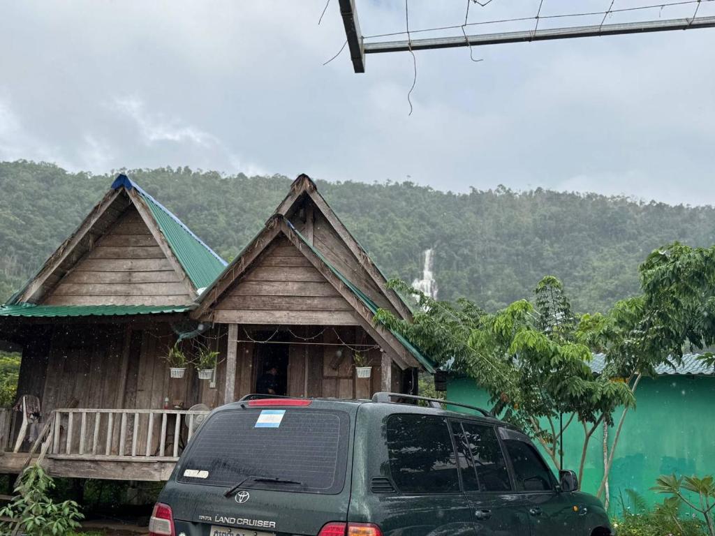 a van parked in front of a house next to a lake at Chamka Sne LyLy Resort in Phumĭ Stœ̆ng Chral