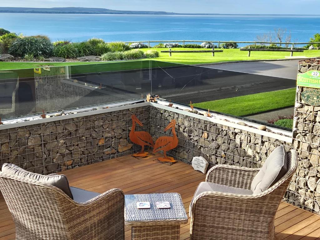 a patio with two chairs and a stone wall at Whaler's Cove in Portland