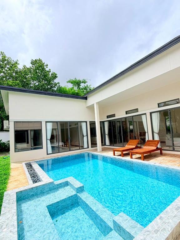 a swimming pool in the backyard of a house at Bella Villa V1 in Koh Lone