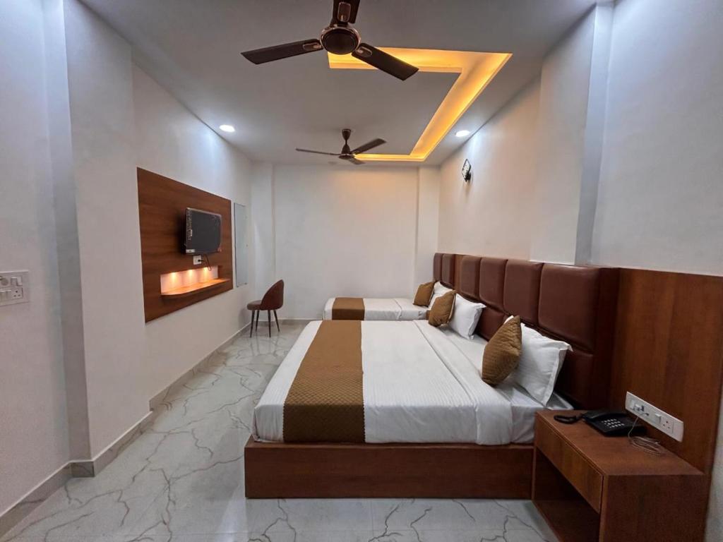 a bedroom with a bed and a ceiling fan at Hotel Shree Amrit Ganga in Haridwār