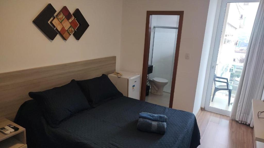 a bedroom with a bed with a blue blanket at Lagoa Flats in Lagoa Santa