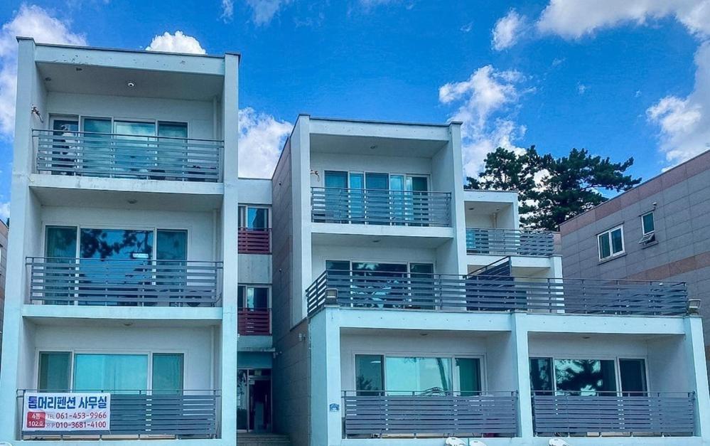 an apartment building with balconies on the side of it at Muan Topmeori Pension in Muan