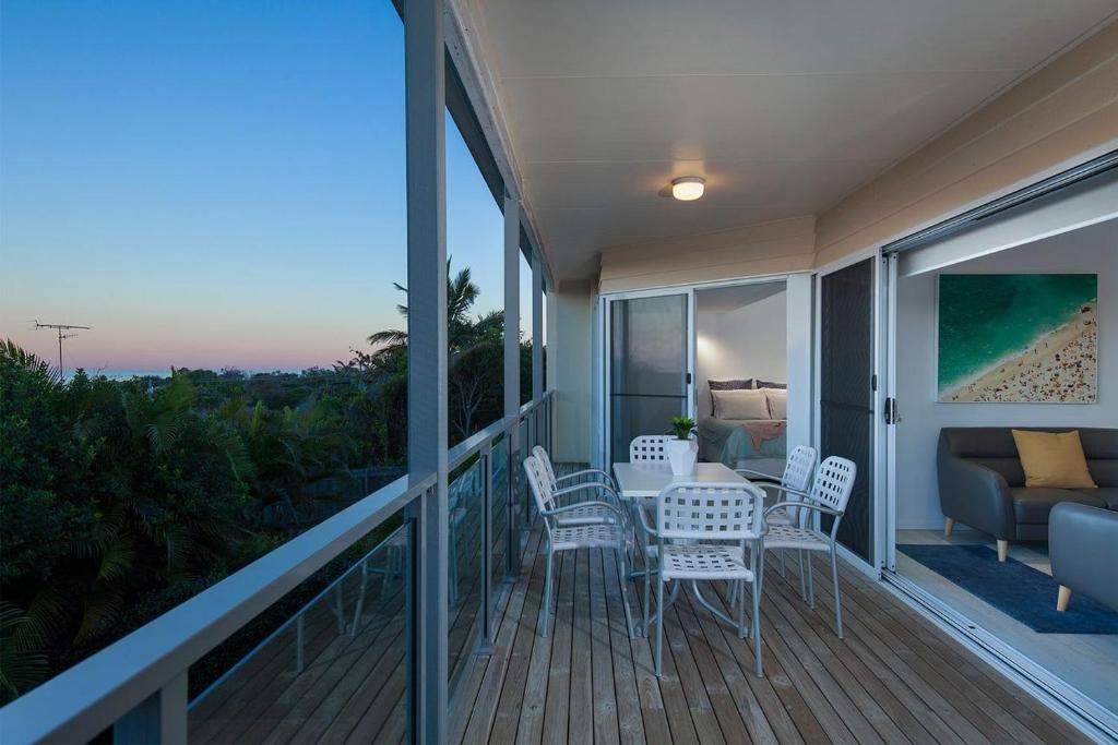 a balcony with a table and chairs and a couch at Villa Pandanus in Peregian Beach