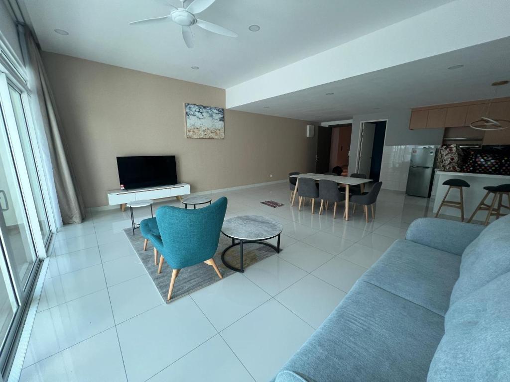 a living room with a blue couch and a table at Homestays Batu Ferringhi in Batu Ferringhi