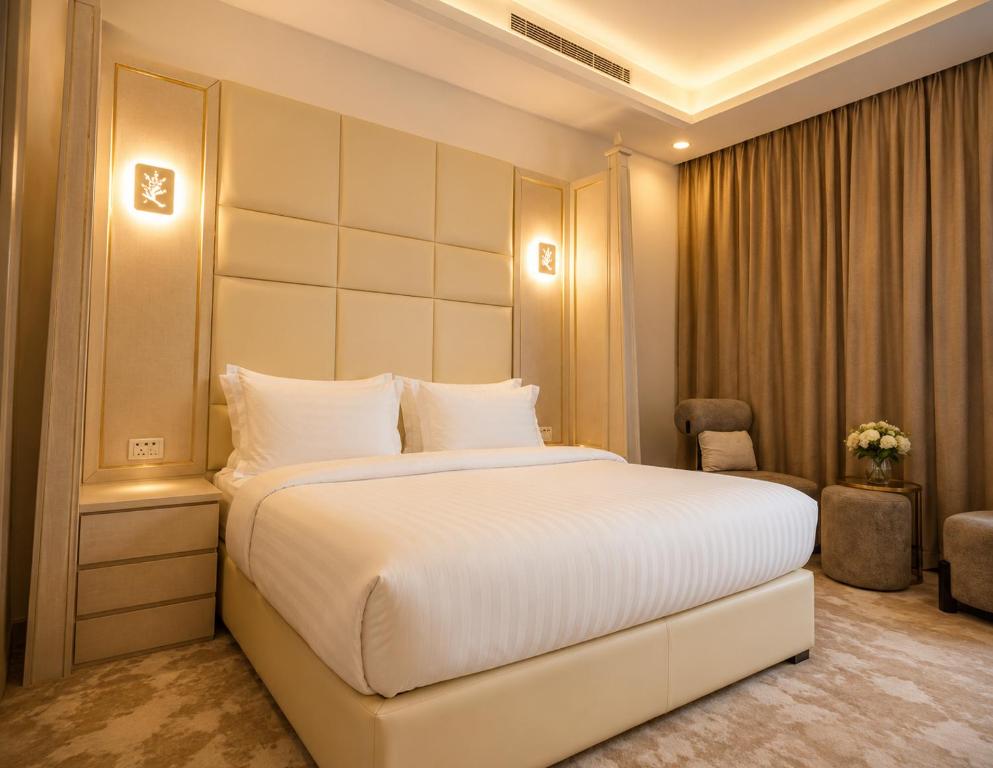 a bedroom with a large white bed and a chair at Qasr Arin Aprtments For Serviced Apartments شقق قصر ارين للشقق المخدومة in Jeddah