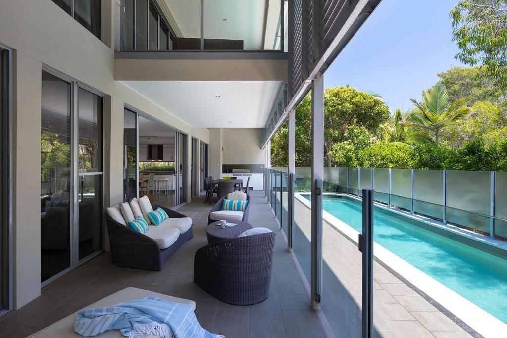 a balcony of a house with a swimming pool at Yaroomba Beach House in Yaroomba