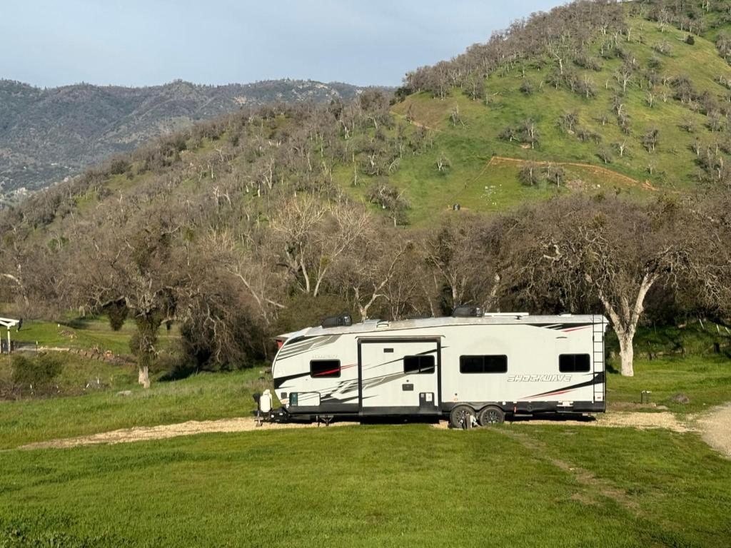 a white trailer parked in a field with a hill at Waxberry Trailer by Kings Canyon and Sequoia National Parks in Squaw Valley