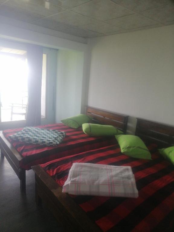 a bedroom with a large bed with green pillows at Munro haputale in Haputale