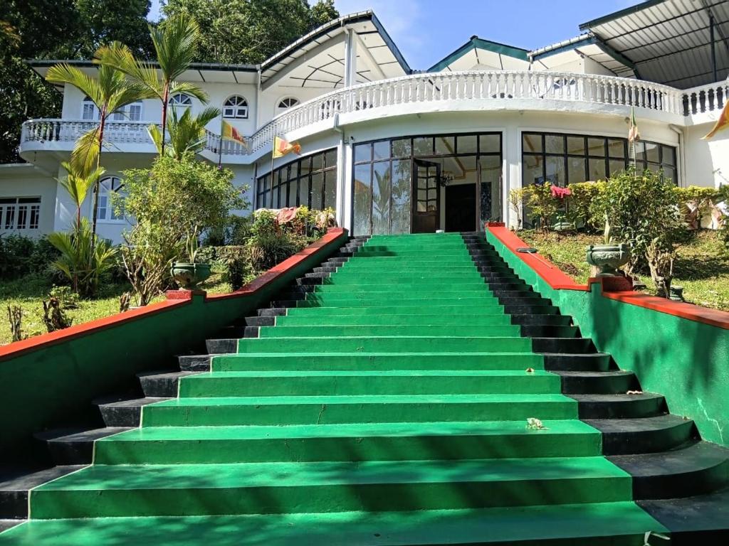 a house with green stairs in front of it at Royal Mount Hotel in Pussellawa