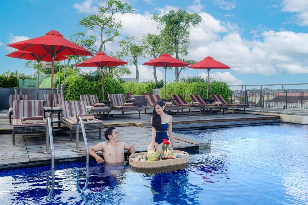 a man and a woman in a swimming pool at Sevn Legian in Legian