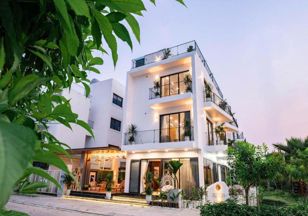 a white house with plants in front of it at Villa The Pearl -Vlasta Sầm Sơn in Sầm Sơn