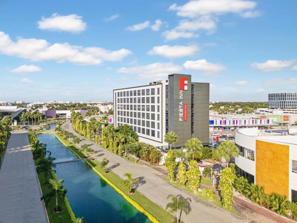 arial view of a hotel with a river and palm trees at Fiesta Inn Express Cancún Cumbres in Cancún