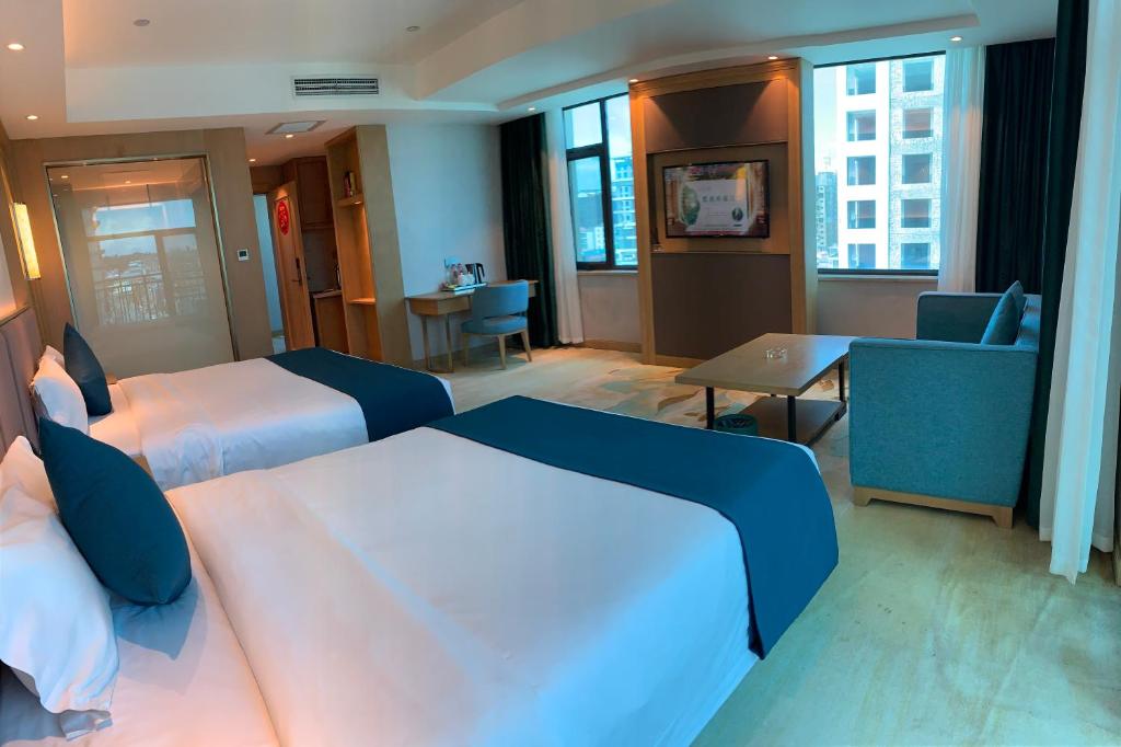 a hotel room with two beds and a living room at SENNA SUNSHINE INTERNATIONAL HOTEL in Sihanoukville