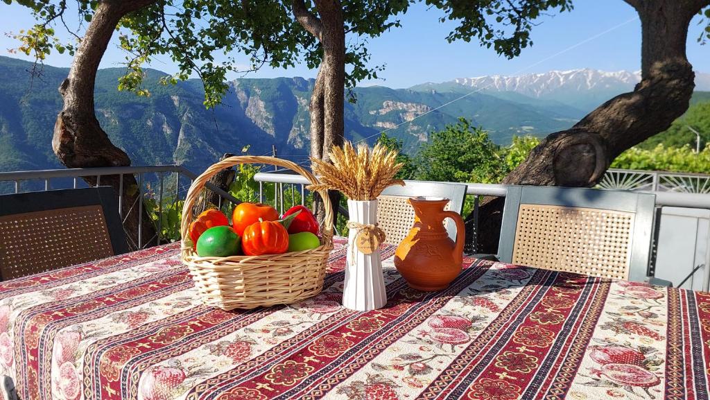 a table with a basket of fruit and a vase at Gohar Bed and Breakfast in Tatʼev