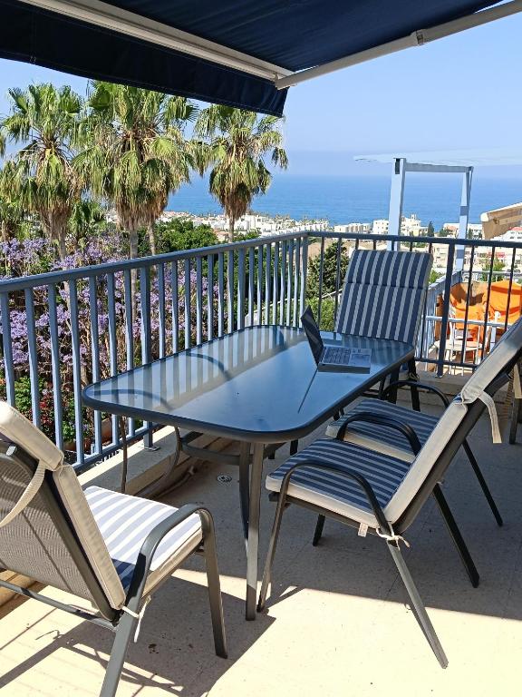 a table and chairs on a balcony with the ocean at Two BR Sea View with Balcony and Pool Paphos in Khlorakas