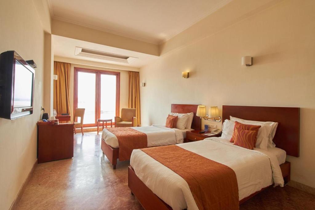 Postel nebo postele na pokoji v ubytování Royal Sarovar Portico Siliguri