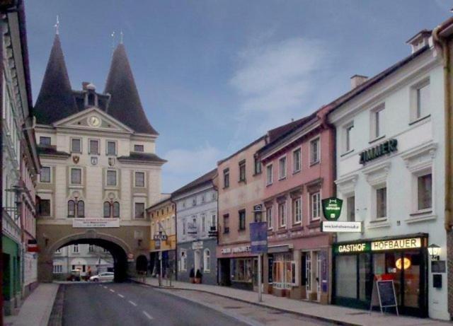 an empty city street with an archway and buildings at Gasthof Hofbauer in Schwanenstadt