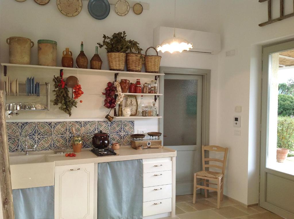 a kitchen with a counter and shelves with pots and pans at Agriturismo Santo Stefano - Monopoli in Monopoli