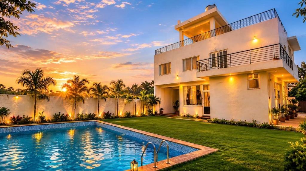 a villa with a swimming pool in front of a house at Mangal Uday Villa in Jaipur