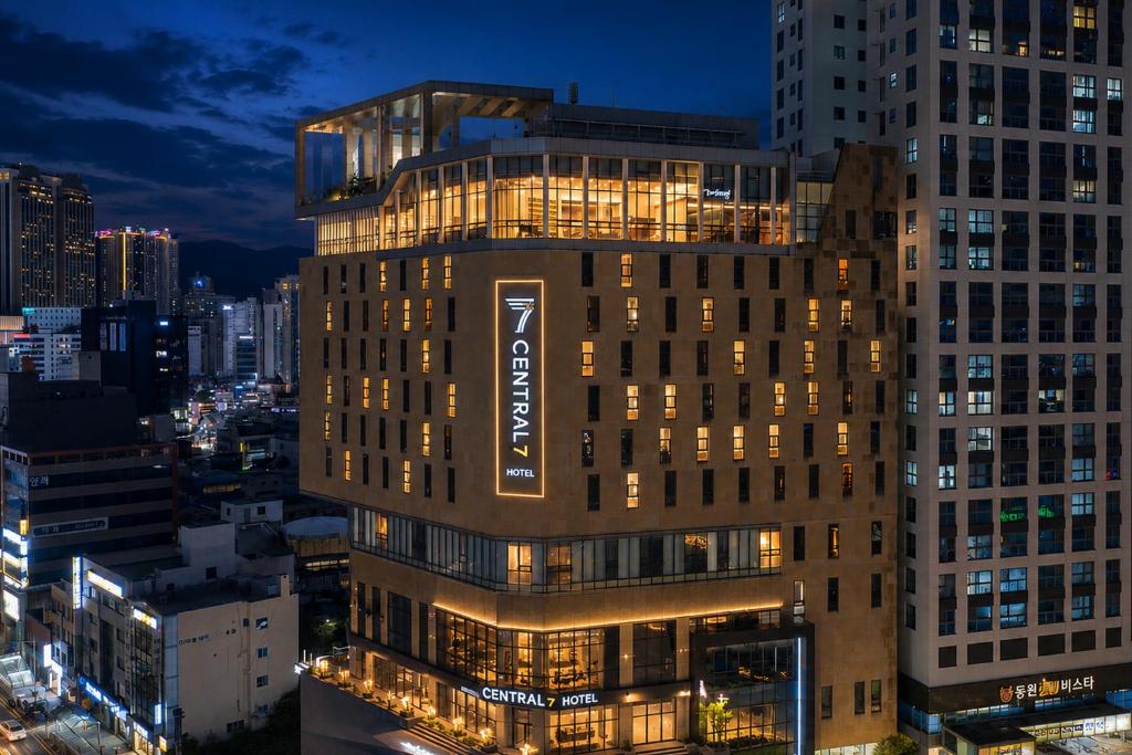 a tall building with a sign on it at night at Central Seven Hotel by Kwon Busan Seomyeon in Busan