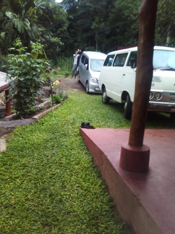 a couple of white vans parked in the grass at Duleni villa in Haldummulla