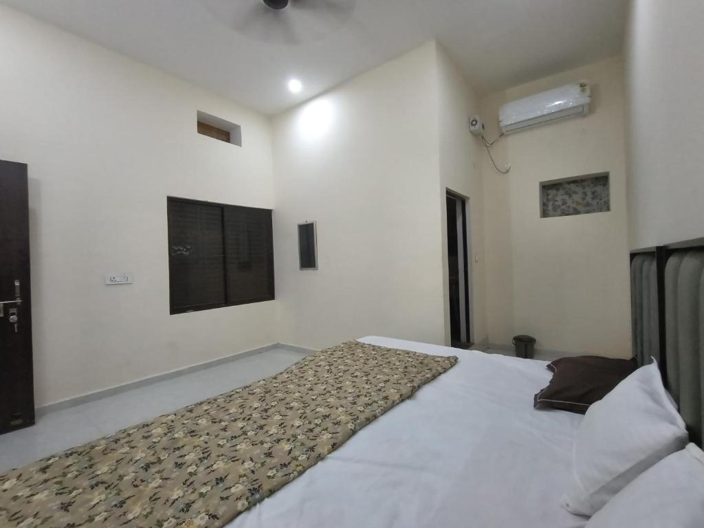 a bedroom with a large white bed in a room at Pramod Residency in Chitrakoot