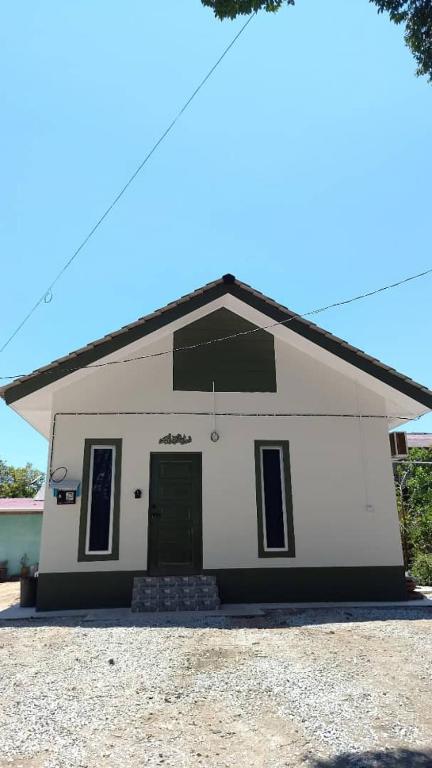 a small white building with a green door at Adeeb Homestay in Tumpat