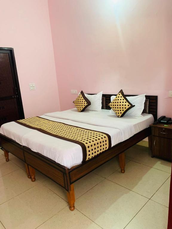a bed with two pillows on it in a room at Hotel Mahadev Home-Stay !! Near Chandigarh It'l Airport in Chandigarh Airport