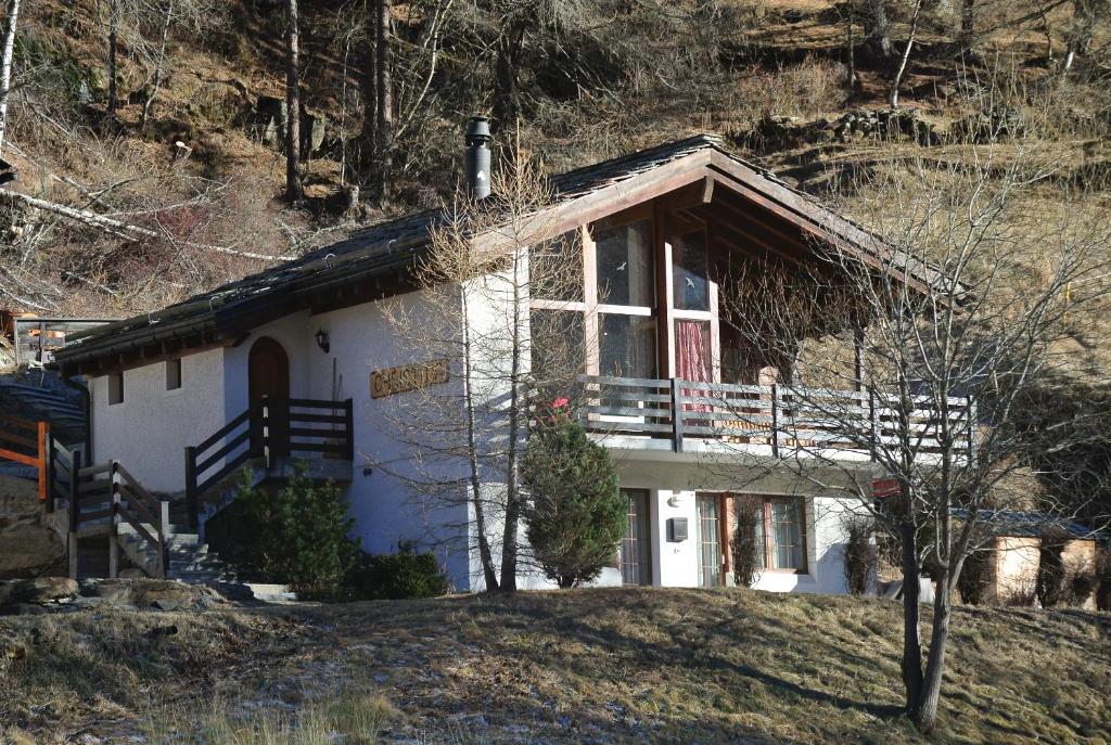 une petite maison blanche au sommet d'une colline dans l'établissement Chalet Christitia, à Saas-Grund