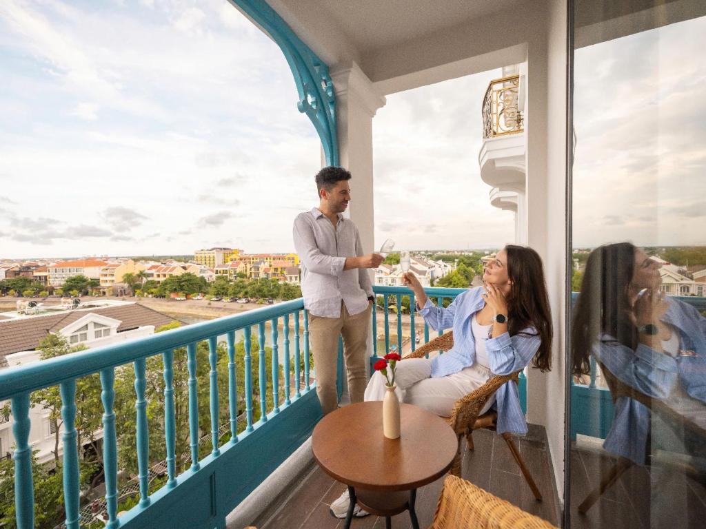 a man standing on a balcony with a woman at Little Residence - A Boutique Hotel & Spa in Hoi An