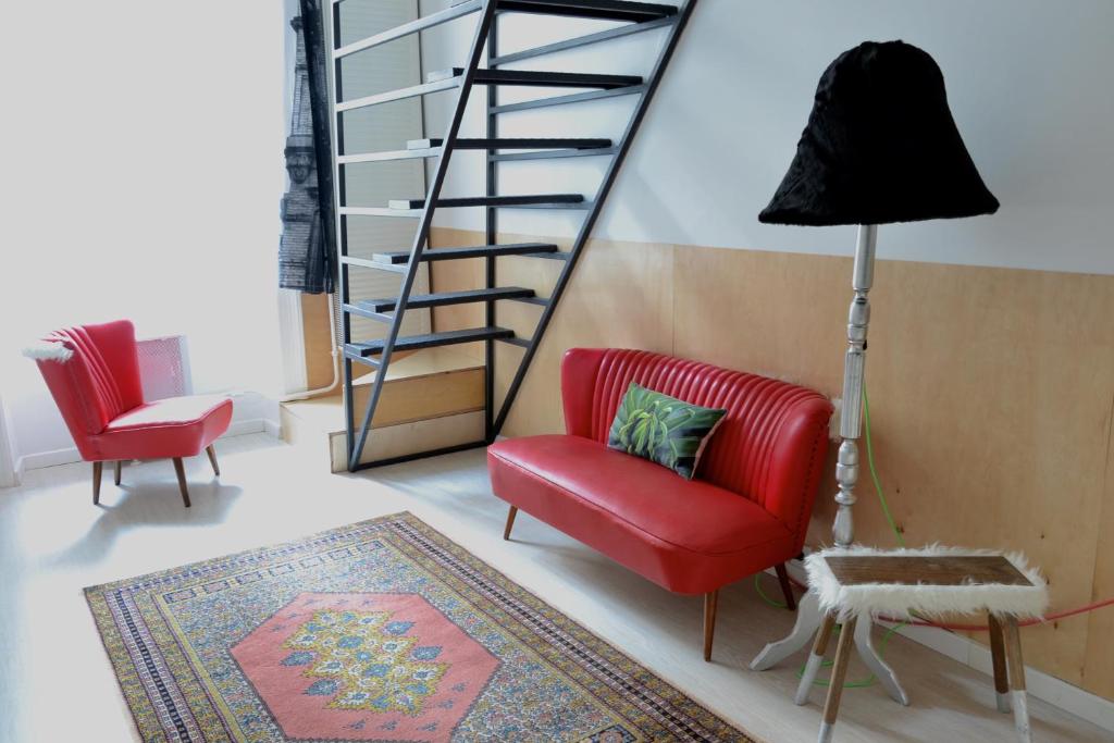 a living room with a red chair and a staircase at Twenty2 Apartment in Budapest