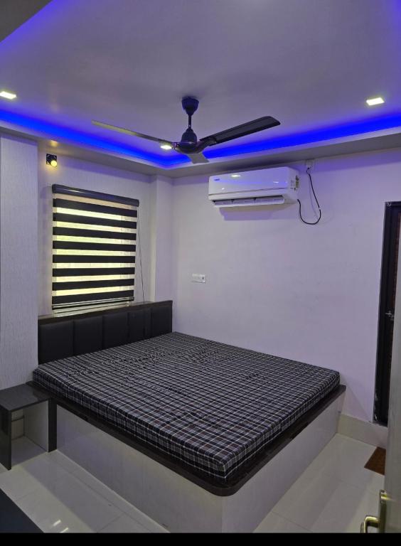 a bed in a room with a blue light at Mandapam Hotel & Restaurant in Dhanbād