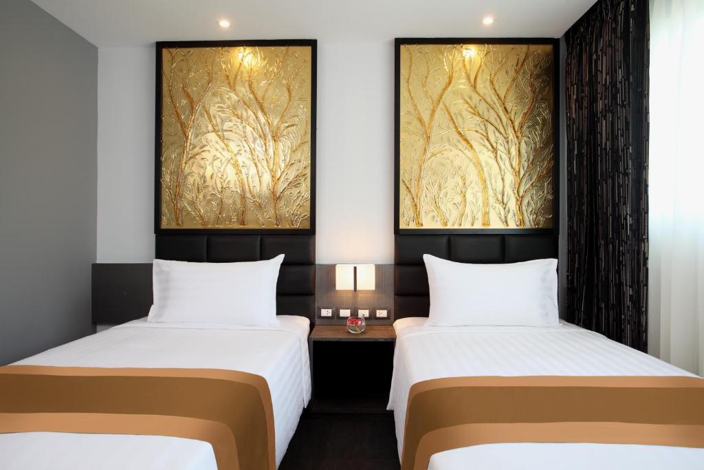 Postel nebo postele na pokoji v ubytování Nova Express Pattaya Hotel