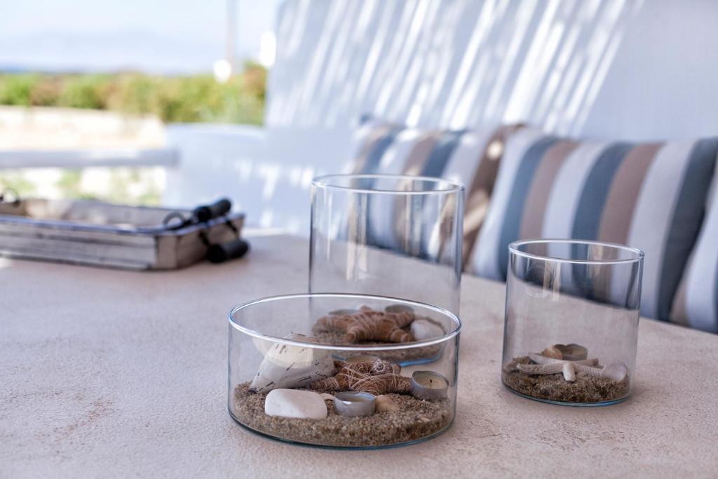 two glass containers filled with rocks and seashells on a table at Glyfada's Villa in Kastraki Naxou