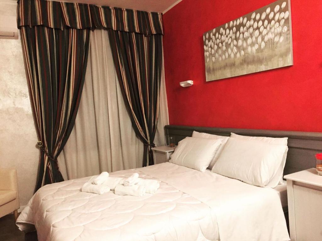una camera con un letto bianco con una parete rossa di Ai Colli a Teolo