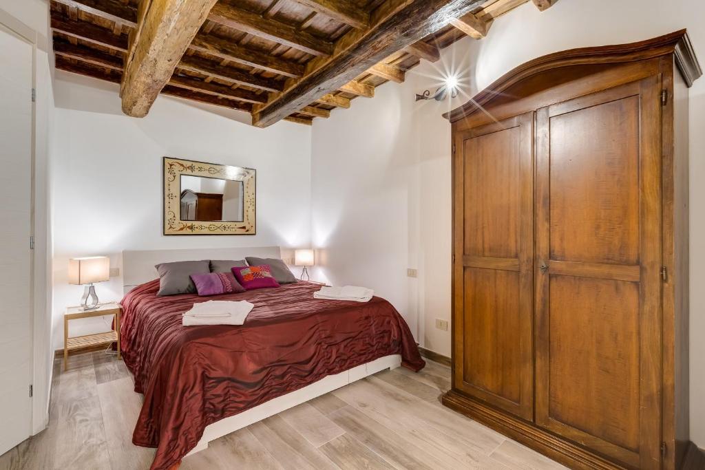 una camera con letto e grande armadio in legno di Pellegrino Campo de' Fiori Suite a Roma