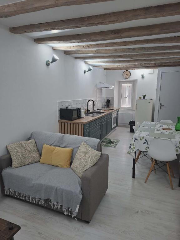 a living room with a couch and a table and a kitchen at appartement calme et climatisé Chamaillard 2 in L'Ile-Bouchard