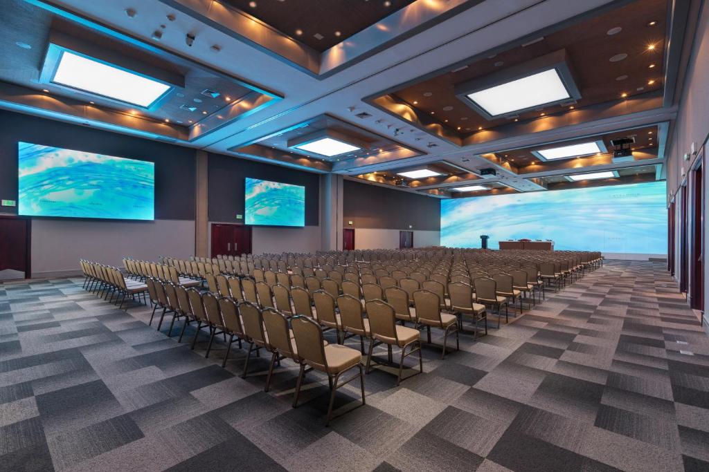 an empty room with chairs and large screens at Catalonia Santo Domingo in Santo Domingo