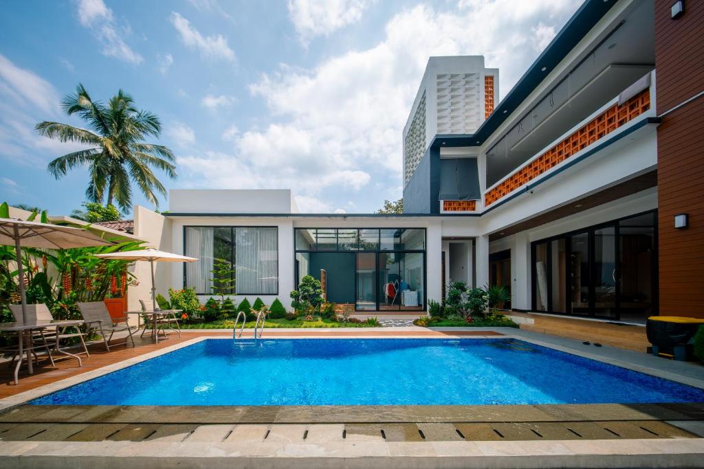 a house with a swimming pool in front of it at Bhumi Nawasena in Semalen
