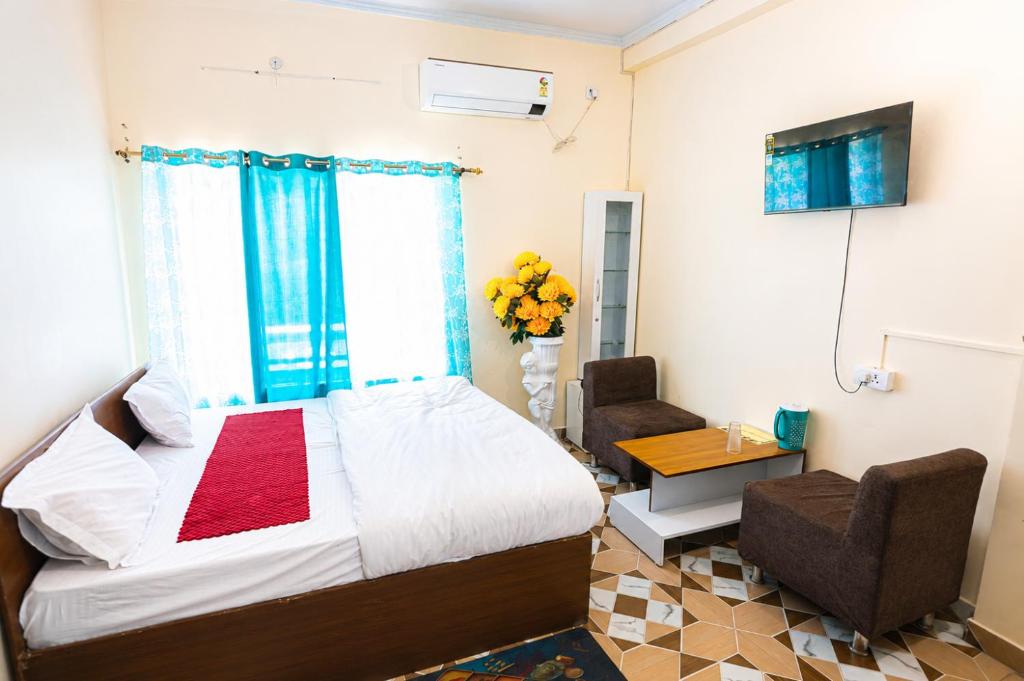 a bedroom with a bed and a table and chairs at Green Valley Hotel - Srinagar in Srīnagar