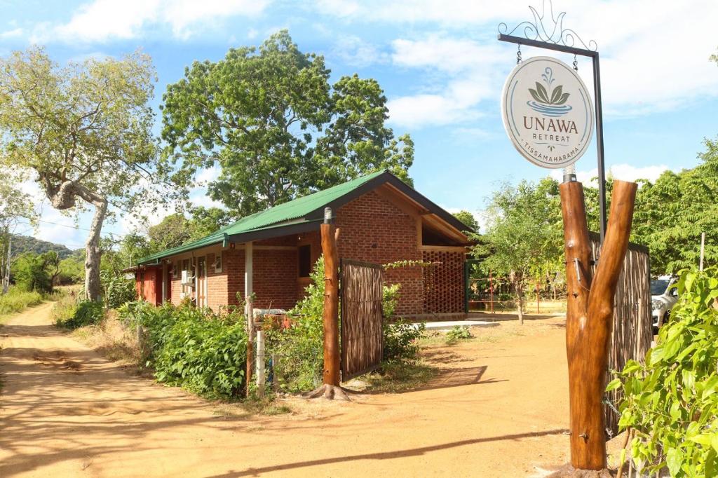 a sign in front of a small building at Unawa Retreat in Tissamaharama